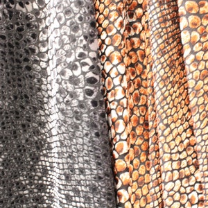 Peut inclure: Gros plan sur un tissu à motif peau de serpent. Le tissu est en trois couleurs : noir, blanc et marron.