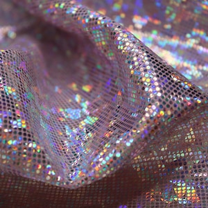 May include: Close-up of iridescent pink fabric with a subtle shimmer. The fabric has a textured, dot-like pattern.