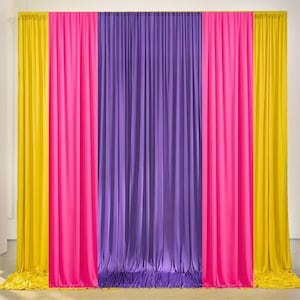 May include: A colourful backdrop with three vertical panels of fabric. The panels are in bright colours: yellow, hot pink, and purple. The fabric is draped in vertical folds, creating a textured appearance. Suitable for events.