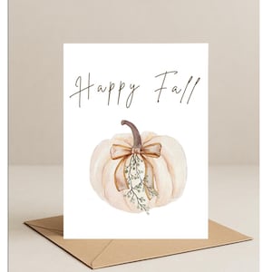 以下が含まれることがあります： クリーム色のカボチャと茶色の茎、ベージュのリボンを描いた水彩イラストのグリーティングカード。「Happy Fall」とエレガントな筆記体で書かれています。茶色の封筒に入っています。