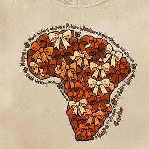 Peut inclure: Sweat-shirt crème avec un motif du continent africain composé de nœuds marron et crème. Les mots "Black history", "Love", "Pride", "Wisdom", "Hope", "Power" et "Culture" sont écrits autour du continent.