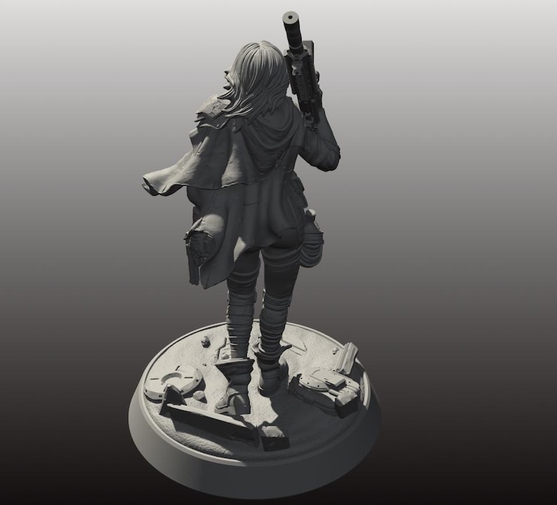 以下が含まれることがあります： 未来的な衣装を着た女性キャラクターの灰色のフィギュアで、ライフルを持っています。フィギュアは、散らばった破片のある円形のベースに立っています。キャラクターはフード付きのマントと戦術的なギアを着用しています。