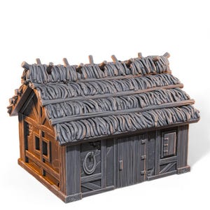 Puede incluir: Un edificio en miniatura gris con techo de paja. La estructura tiene paredes de madera, una puerta y pequeñas ventanas. Una cuerda está unida a la puerta. El techo está hecho de material similar a la paja.