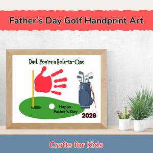 May include: A framed Father's Day golf-themed handprint art print. The print features a red handprint, a golf bag, a golf ball, and the text "Dad, You're a Hole-in-One." The words "Happy Father's Day" and the year "2026" are also included.