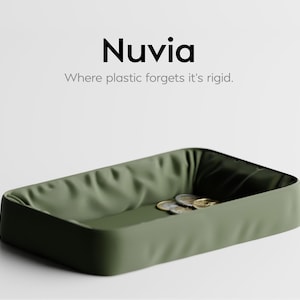 Puede incluir: Una bandeja rectangular verde oliva con un interior suave y texturizado. La bandeja contiene varias monedas y el texto "Nuvia: Where plastic forgets it's rigid."