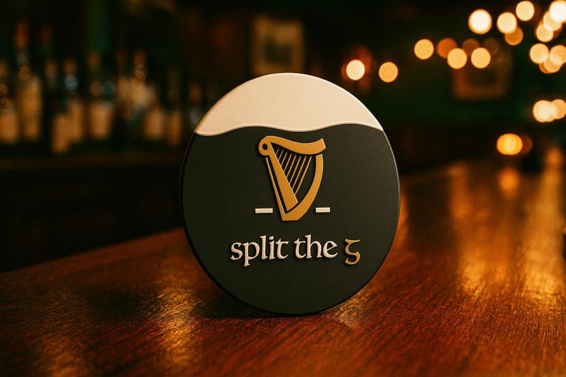 Op de afbeelding: Een ronde, donkergroene bierviltje met een witte bovenkant en een gouden harp-logo. De tekst "split the 5" is in goud. De bierviltje ligt op een houten bar.