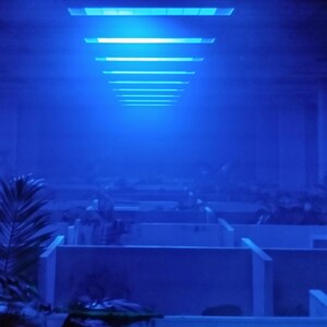 Photo d'ambiance montrant le reflet de la lumière LED bleue du cadre sur une zone de bureau infestée.