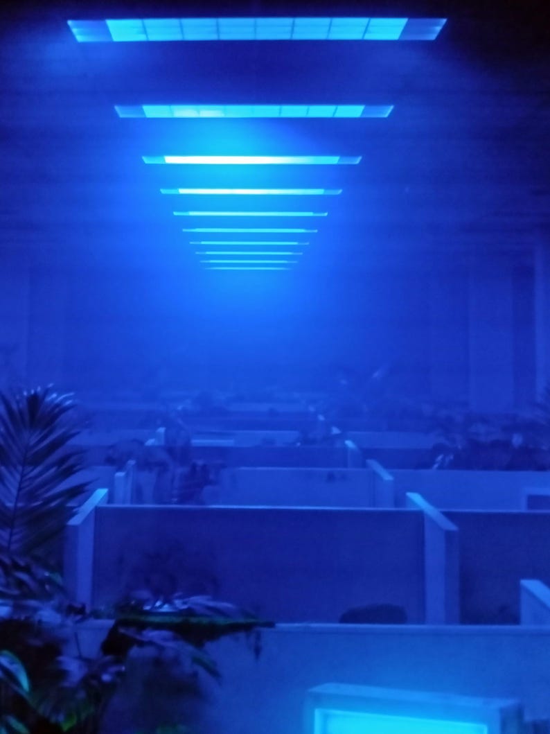Photo d'ambiance montrant le reflet de la lumière LED bleue du cadre sur une zone de bureau infestée.