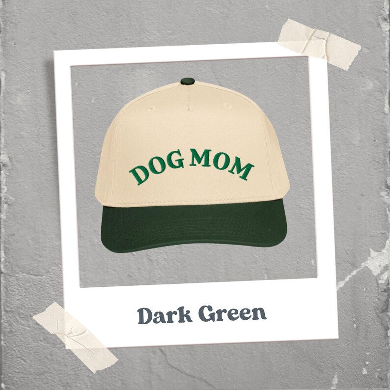 May include: A baseball cap with a cream-colored crown and a dark green brim. The words "DOG MOM" are embroidered in green on the front. The image is framed with a white border and the text "Dark Green" is below the cap.