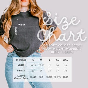 May include: A charcoal gray boxy t-shirt with a size chart overlay. The text reads Size Chart, Comfort Colors 3023CL Heavyweight Boxy T-Shirt, and includes a table with width, length, and sleeve center back measurements in inches for sizes S to XXL.