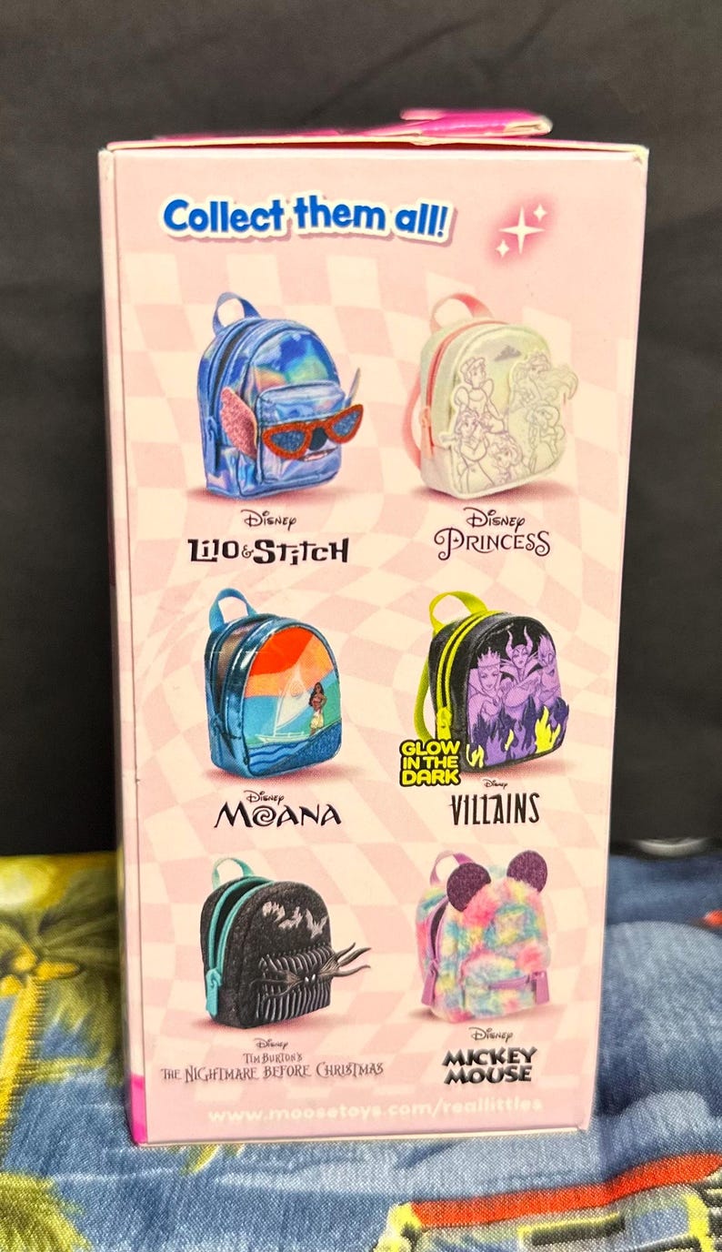 Puede incluir: Una caja rosa con mini mochilas tem&aacute;ticas de Disney. Los dise&ntilde;os incluyen Lilo & Stitch, Disney Princess, Moana, Villains, The Nightmare Before Christmas y Mickey Mouse. El texto "Collect them all!" se muestra en la parte superior.