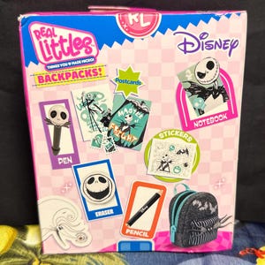 Puede incluir: Un set de mochila Real Littles Disney con Jack Skellington. La caja incluye un bol&iacute;grafo, una goma de borrar, un l&aacute;piz, un cuaderno, pegatinas y postales. La caja es rosa, azul y blanca con los logotipos de Disney y Real Littles.