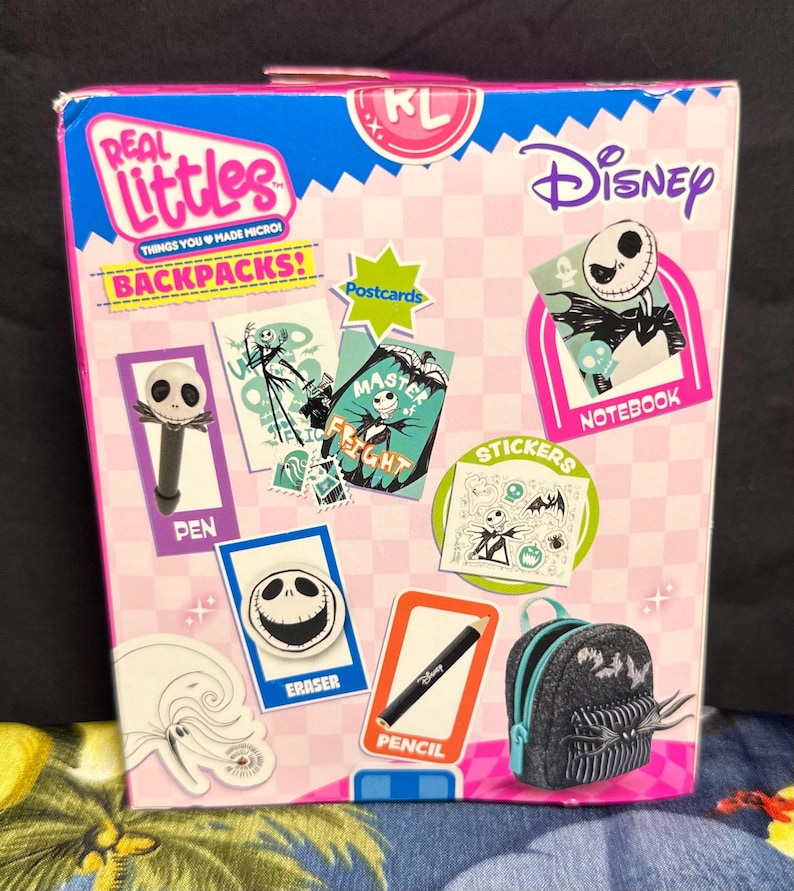 Puede incluir: Un set de mochila Real Littles Disney con Jack Skellington. La caja incluye un bol&iacute;grafo, una goma de borrar, un l&aacute;piz, un cuaderno, pegatinas y postales. La caja es rosa, azul y blanca con los logotipos de Disney y Real Littles.