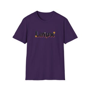Puede incluir: Camiseta morada con la palabra "Linux" en una fuente colorida y estilizada. El dise&ntilde;o incluye peque&ntilde;os elementos gr&aacute;ficos como una carita sonriente y una estrella. La camiseta est&aacute; hecha de un material suave.