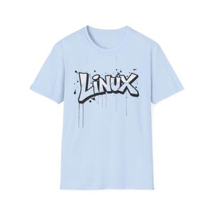 Może przedstawiać: Jasnoniebieska koszulka z napisem "Linux" w czarno-białym stylu graffiti. Tekst ma efekt kapania, z czarnymi plamami farby wokół liter. Koszulka ma okrągły dekolt i krótkie rękawy.