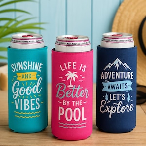May include: Three beverage can coolers in teal, pink, and navy blue. The teal cooler says "Sunshine and Good Vibes." The pink cooler says "Life is Better by the Pool." The navy cooler says "Adventure Awaits, Let's Explore."