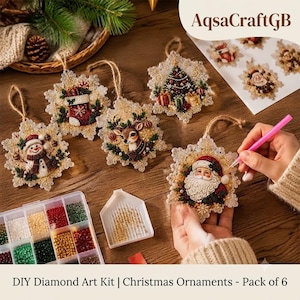 Peut inclure: Un kit de broderie diamant DIY comprenant six décorations de Noël en forme de flocon avec des motifs de bonhomme de neige, chaussette, renne, sapin et Père Noël. Inclut un organisateur de perles, un plateau et un stylet rose.