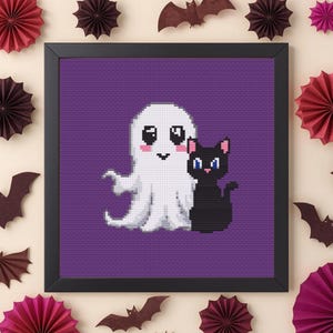 Könnte beinhalten: Ein quadratisch gerahmtes Kreuzstichbild mit einem Pixel-Art-Motiv eines weißen Geistes mit rosa Wangen und einer schwarzen Katze mit blauen Augen auf violettem Grund, umgeben von dekorativen Papierfächern und Fledermäusen aus Papier.