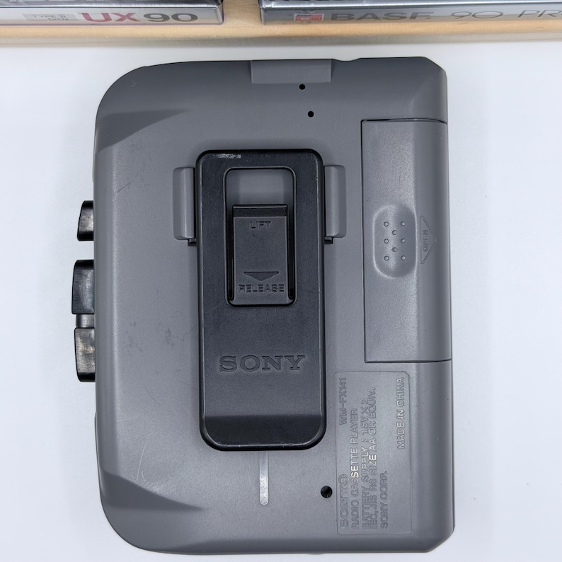 Peut inclure: Un lecteur de cassettes Walkman Sony WM-FX41 gris. Le lecteur poss&egrave;de un clip noir, des boutons et un m&eacute;canisme de lib&eacute;ration. Le logo Sony est visible. Appareil audio vintage.
