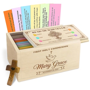 May include: A wooden box set for First Holy Communion, featuring a cross, dove, and the name "Mary Grace" with a date. The box contains color-coded Bible verses and a wooden cross. The set includes cards with Bible verses.