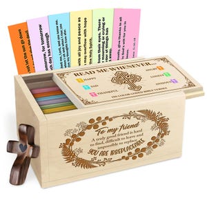 May include: A wooden box set with a cross-shaped handle and a decorative cross. The box contains colourful Bible verses and has the text "Read Me Whenever" on the lid. The box is engraved with the words "To my friend" and "You are irreplaceable."