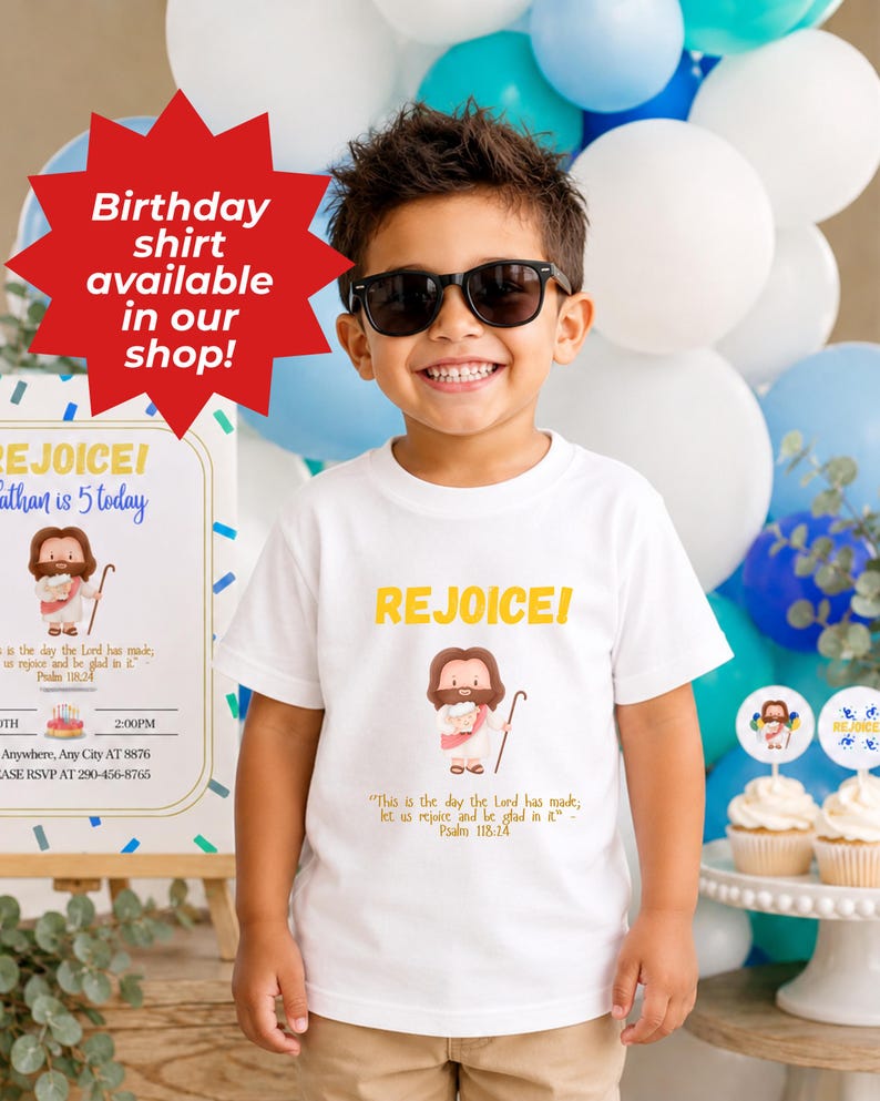 K&ouml;nnte beinhalten: Ein wei&szlig;es T-Shirt mit dem Wort "REJOICE!" in Gelb, mit einer Cartoon-Illustration von Jesus. Das Shirt enth&auml;lt auch den Text "Dies ist der Tag, den der HERR gemacht hat; lasst uns jubeln und uns an ihm freuen" und "Psalm 118,24".