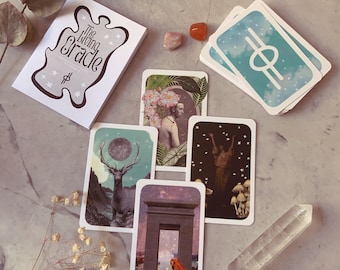 May include: A set of oracle cards with colorful illustrations and text. The cards feature a variety of themes, including nature, animals, and spirituality. The cards are laid out on a light gray surface with a small crystal and a book titled "The Living Oracle".