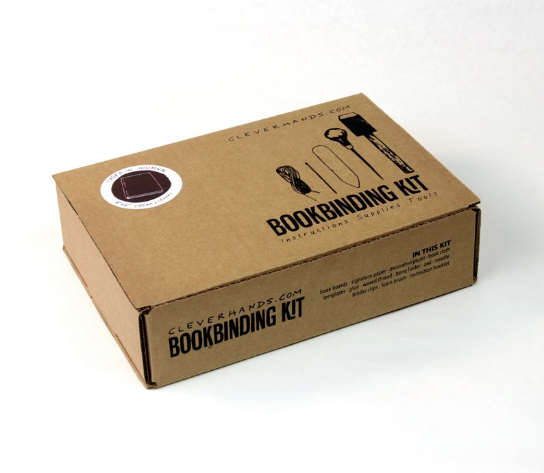 May include: A brown cardboard box with the text "CLEVERHANDS.COM BOOKBINDING KIT instructions Supplies Tools" printed on the front. The box contains a bookbinding kit with tools and supplies.