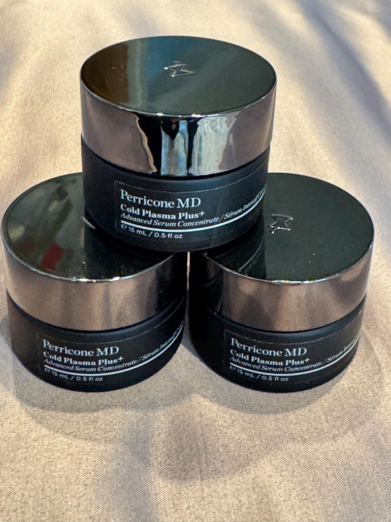 May include: Three black cosmetic jars with silver lids are stacked. Each jar is labeled "Perricone MD Cold Plasma Plus+ Advanced Serum Concentrate" and contains 15 mL / 0.5 fl oz. The jars are arranged in a triangular formation.