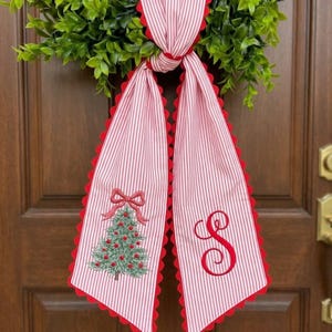As captured in our product images, one side of the sash features a beautifully detailed embroidery of a festive Christmas tree adorned with raised red ornaments and a matching bow. The other side is customized with a luxury, vintage-style monogram letter of your choice, making it a truly unique piece for your family home or a thoughtful housewarming gift.