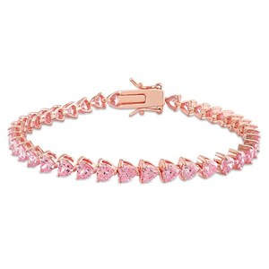Op de afbeelding: Roségouden armband met een reeks roze hartvormige stenen. De armband heeft een veilige sluiting. De stenen zijn gelijkmatig verdeeld, waardoor een doorlopend patroon ontstaat. Ontworpen om om de pols te worden gedragen.