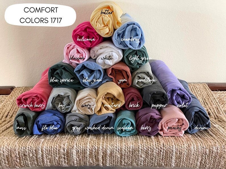 A pyramid-shaped arrangement of rolled-up fabric swatches in various colors, including pink, blue, green, yellow, and purple, with each color labeled.