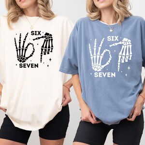 Two women wearing t-shirts with the text "SIX SEVEN" printed on them.
