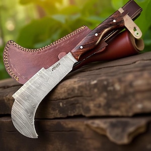 May include: A curved blade knife with a wooden handle and a leather sheath. The blade has a unique pattern, and the handle is adorned with white dots. The knife is resting on a wooden surface, suggesting a rustic or outdoor theme.
