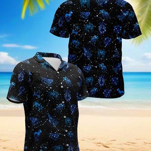 May include: Black button-up shirt with a celestial design featuring blue zodiac constellations and white connecting lines. The shirt has short sleeves and a classic collar, perfect for casual wear. The background shows a beach scene.