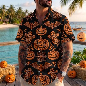 May include: A short-sleeved button-down shirt featuring a black background with an orange pattern of jack-o'-lanterns, flying bats, ghosts, and spider webs. The shirt has a classic collar and a front button closure with white buttons.
