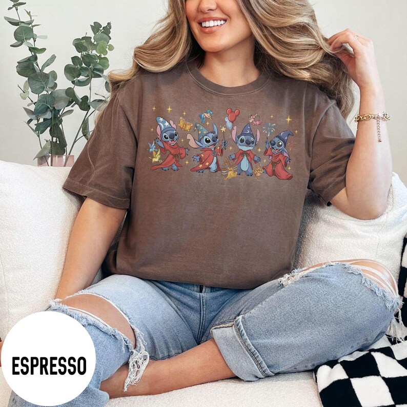 May include: Espresso-colored t-shirt featuring a graphic of four cartoon characters in wizard attire. The characters are blue with various accessories. The shirt is a solid color with the word "ESPRESSO" in a white circle at the bottom.