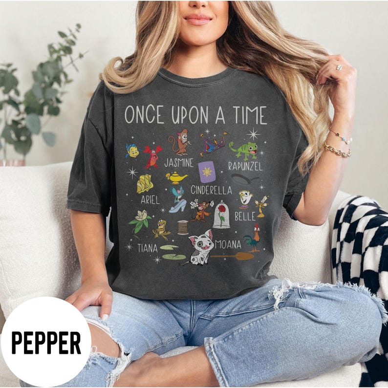 May include: Dark grey t-shirt with the text "ONCE UPON A TIME" and cartoon character illustrations. The shirt features characters like Ariel, Jasmine, Cinderella, and Moana. The word "PEPPER" is printed on the bottom left.