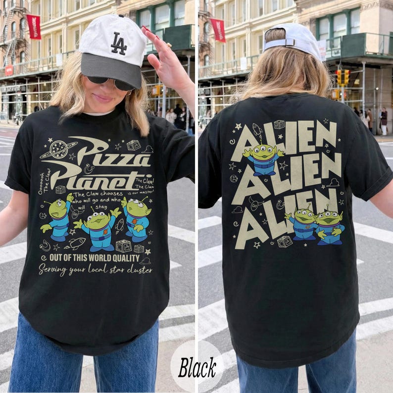 K&ouml;nnte beinhalten: Schwarzes T-Shirt mit Pizza Planet-Logo und Alien-Charakteren. Auf der Vorderseite befindet sich das Pizza Planet-Logo und Text. Auf der R&uuml;ckseite steht das Wort "Alien" wiederholt. Das T-Shirt hat eine bequeme Passform.