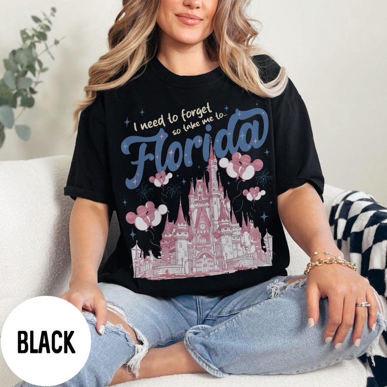 May include: Black t-shirt with the text "I need to forget so take me to Florida" in blue script. The shirt features a pink and white castle graphic with balloons. The word "BLACK" is in a white circle at the bottom.