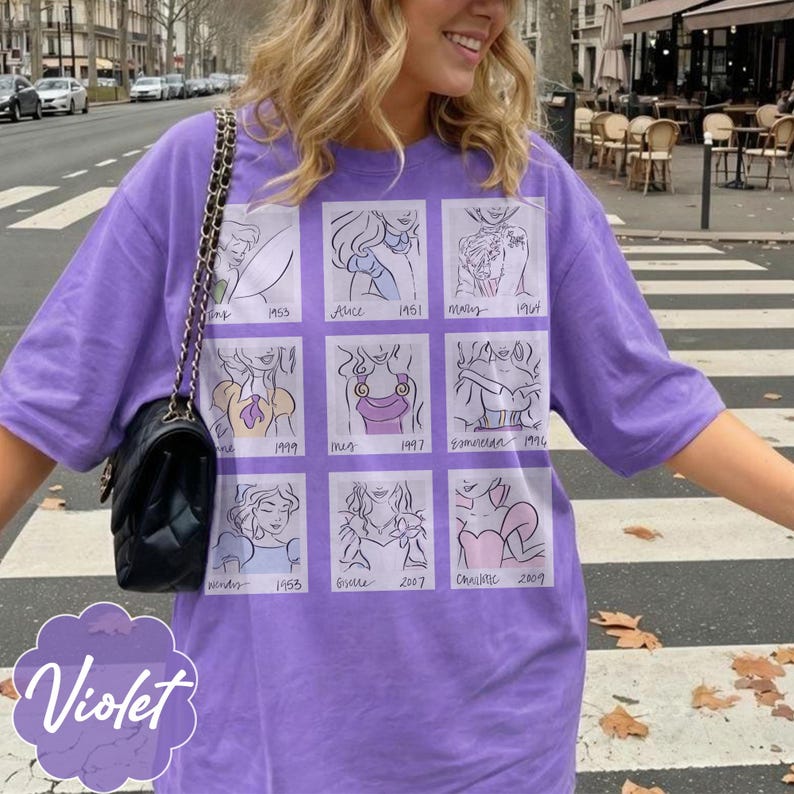May include: A violet-colored t-shirt featuring a grid of cartoon sketches with dates. The sketches appear to be of animated characters. The word "Violet" is written in a cursive font at the bottom left of the shirt.