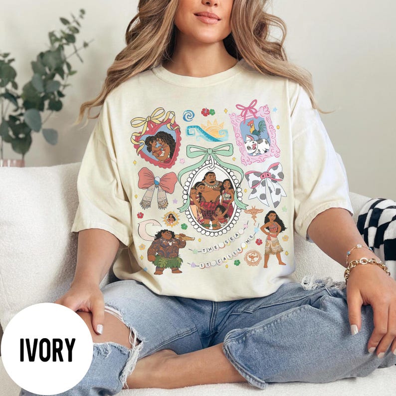 Pu&ograve; includere: T-shirt color avorio con un design grafico colorato con personaggi ed elementi di un popolare film d'animazione. Il design include ritratti incorniciati, fiocchi e la scritta "THE SEA CALLS ME".