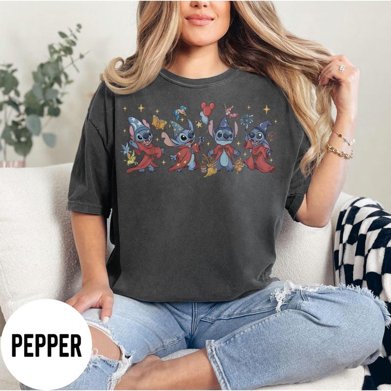 May include: Dark gray t-shirt featuring a cartoon graphic of Stitch characters in wizard costumes. The graphic includes Stitch in red and blue robes, wizard hats, and holding various magical items. The word "PEPPER" is printed in white at the bottom.