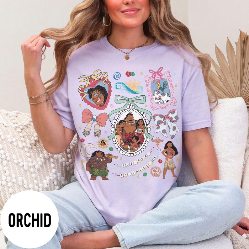 Pu&ograve; includere: T-shirt color orchidea con un design grafico colorato con personaggi ed elementi di un popolare film d'animazione. Il design include ritratti incorniciati, fiocchi e la scritta "THE SEA UT CALLS ME".
