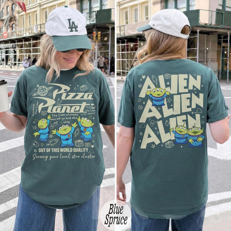 K&ouml;nnte beinhalten: Blaues Spruce-T-Shirt mit dem Pizza Planet-Logo und Alien-Charakteren aus Toy Story. Die Vorderseite des Shirts hat das Pizza Planet-Logo und Aliens. Auf der R&uuml;ckseite des Shirts steht das Wort "ALIEN" wiederholt mit Alien-Charakteren.