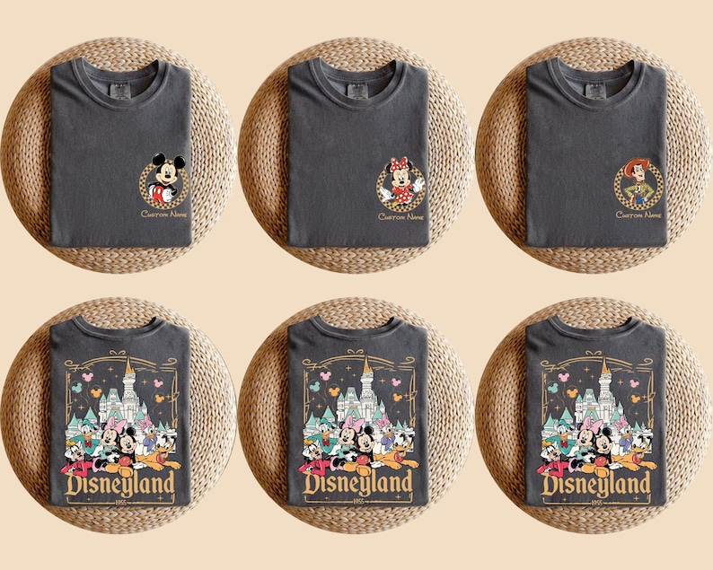 Pu&ograve; includere: Sei magliette grigio antracite sono esposte su tappetini intrecciati. Tre magliette presentano disegni di personaggi di Topolino, Minnie e Jessie. Le altre tre magliette hanno una grafica di Disneyland con vari personaggi e il logo Disneyland.