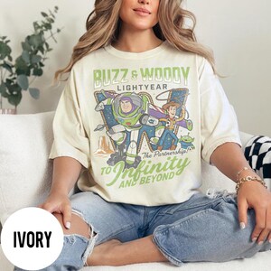 May include: A white ceramic mug with a black handle and the text "But First, Coffee" in a black, handwritten-style font. The mug is on a white surface.