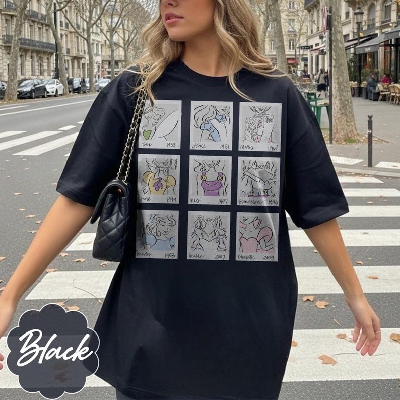 May include: Black t-shirt featuring a grid of nine cartoon illustrations of Disney princesses with their names and release years. The word "Black" is written in a white script on a black background.