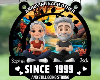 May include: A black and white decorative sign with the text "ANNOYING EACH OTHER" at the top. The sign features cartoon illustrations of a couple and the text "SINCE 1999 AND STILL GOING STRONG".