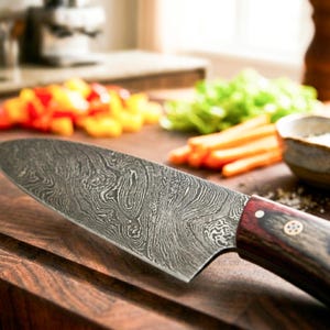 Puede incluir: Un cuchillo de chef con una hoja de acero de Damasco estampada y un mango de madera de color marr&oacute;n rojizo oscuro asegurado con dos remaches met&aacute;licos. La hoja presenta una textura met&aacute;lica ondulada y estratificada con un detalle.